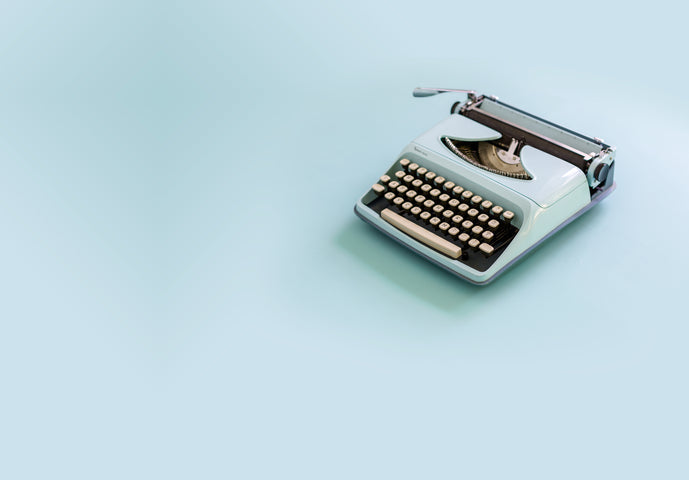 Old school typewriter on light blue background 